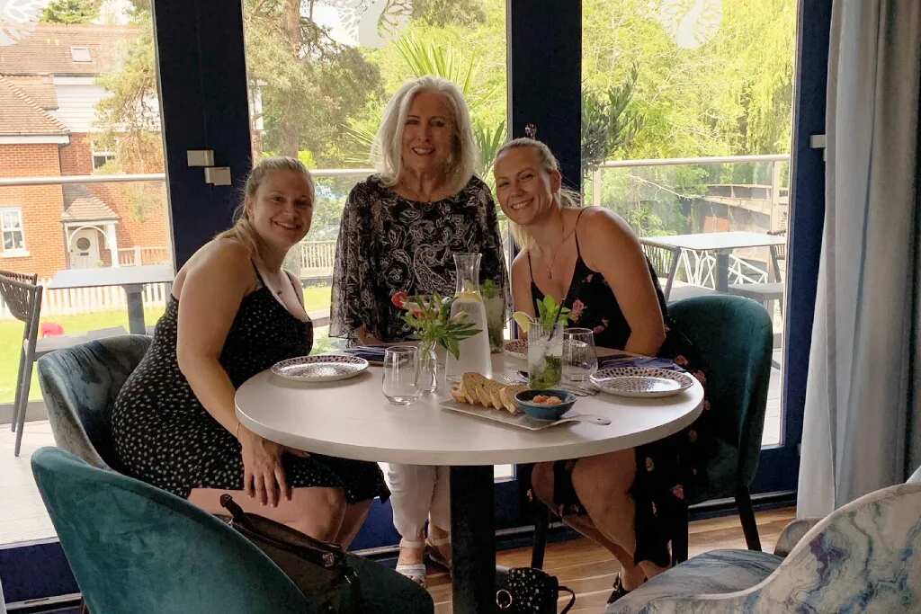 three woman sat in a restaurant smiling