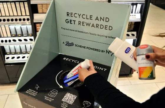 Woman placing her empty toiletries into a boots recycle box