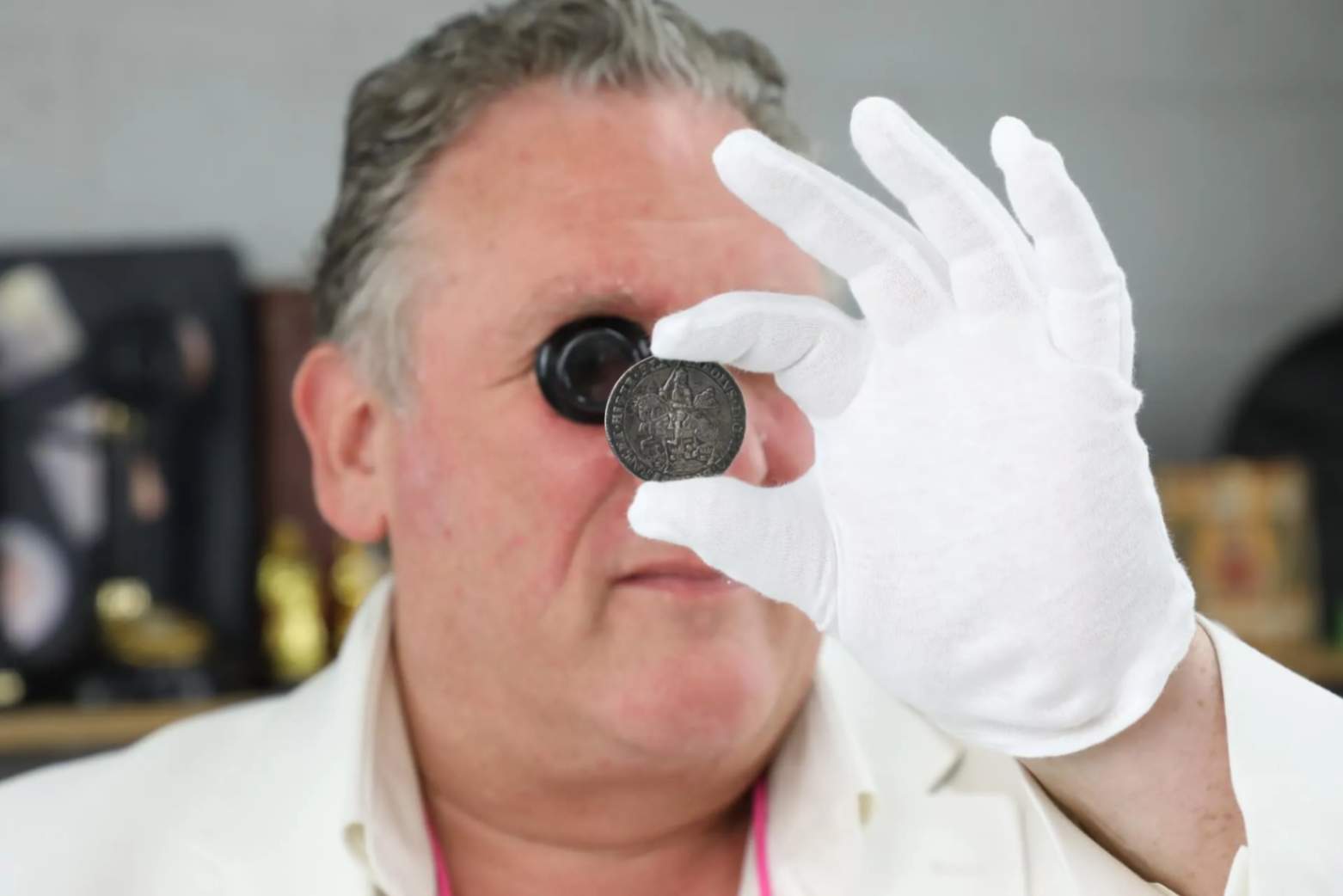man inspects rare coin