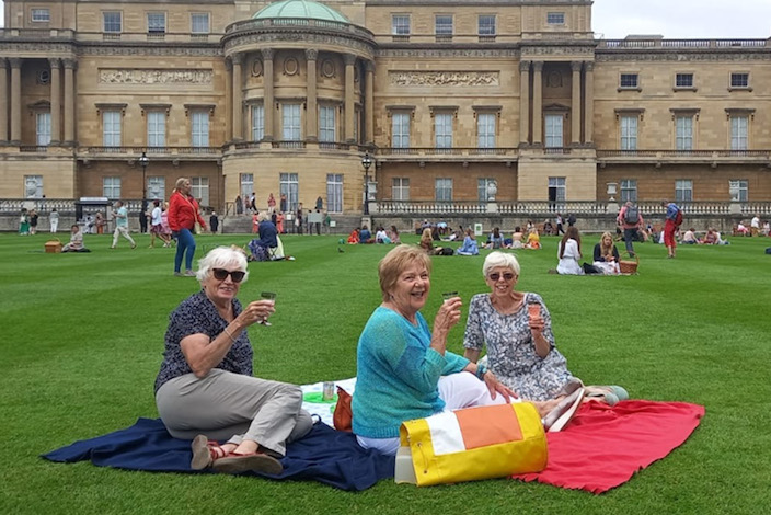 3 older ladies drinking champagne on lawns buckingham palace